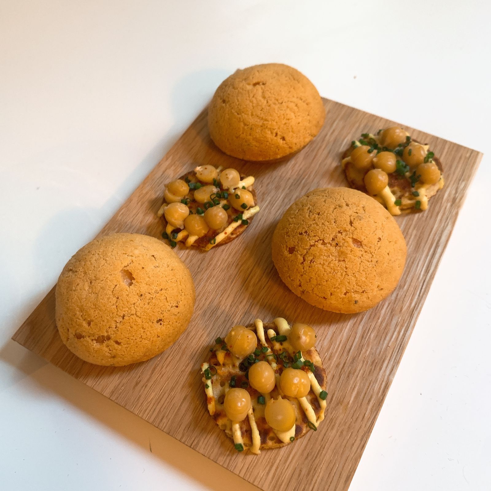 Gougères et toasts aux pois chiches sur une planche en bois